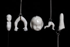 Hollow white porcelain doll's legs pendant produced by Martha Todd, one of the exhibiting artists of The Uncanny: A Centenary.