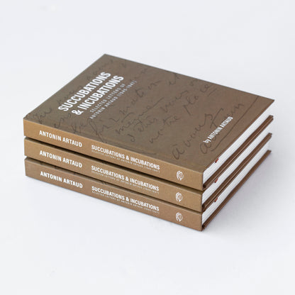Succubations & Incubations - Antonin Artaud. Photo of 3 hardcover copies of the beige book on top of one another.